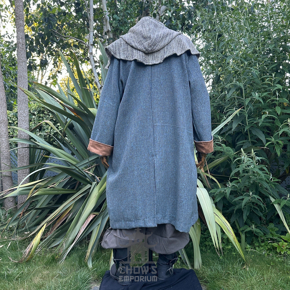 Medieval LARP costume back view, featuring a pirate coat in teal and brown, tunic, hood, trousers, belt, sash and necklace. For Renaissance Faire and historical roleplay events.