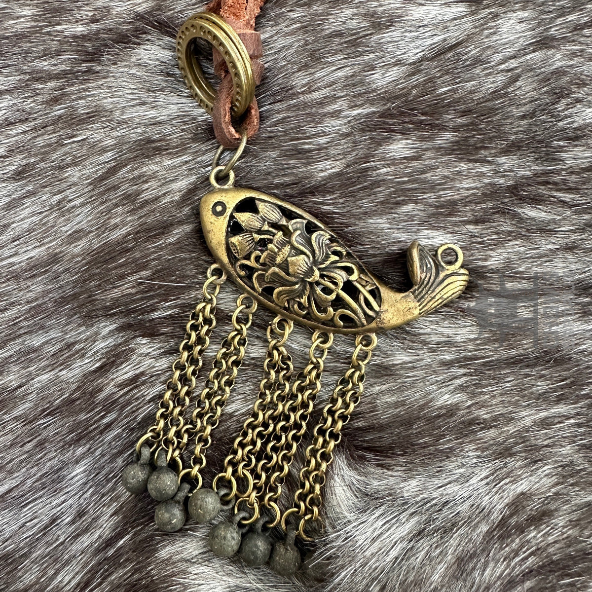 Ornate bronze fish necklace for medieval LARP with chain tassels on fur.