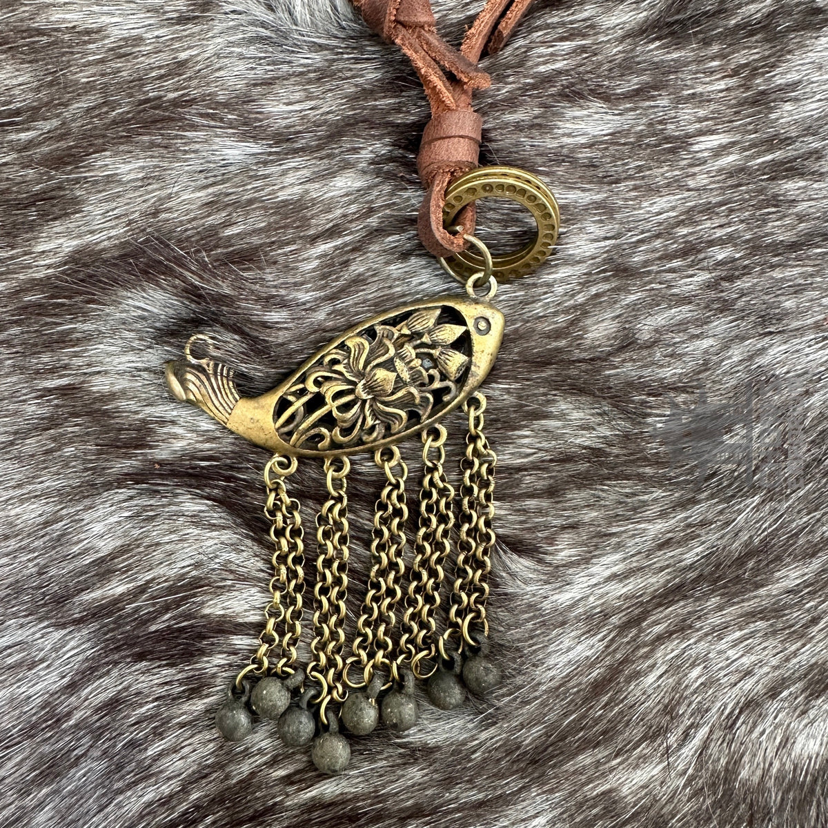 Bronze fish necklace with chain tassels on a fur background for medieval LARP.