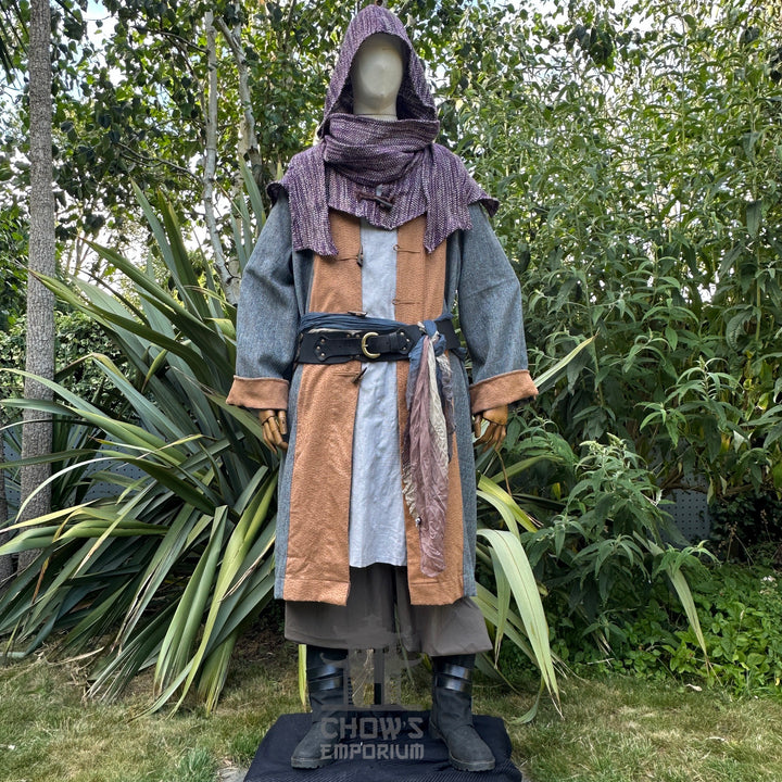 Mannequin wearing a fantasy costume with a hood and leather accents in an outdoor setting.