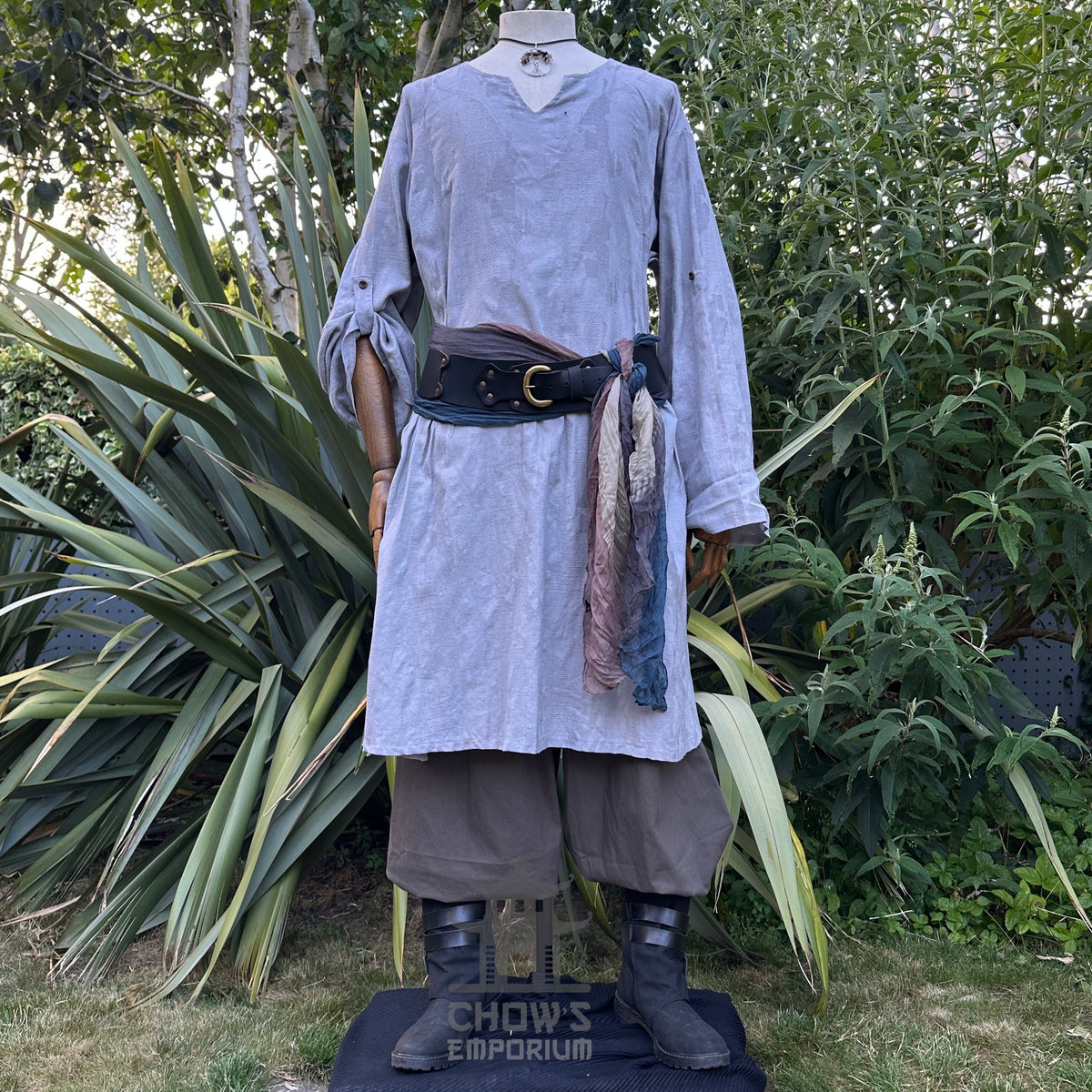 Medieval LARP ocean cleric costume with belt, greenery background.