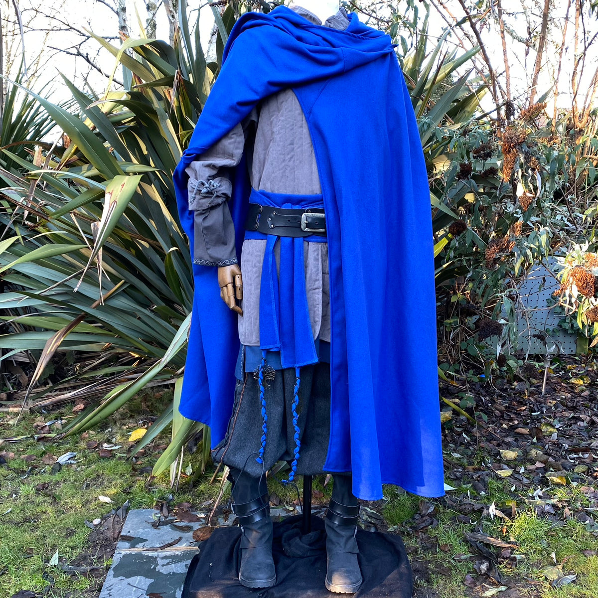 Rear view of blue LARP cloak with hood, over medieval tunic.