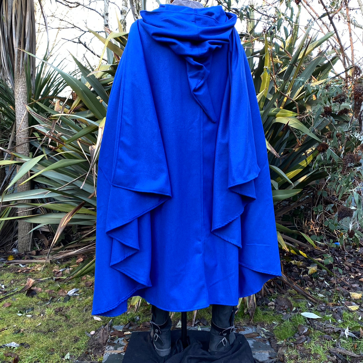 Back view of blue cloak with hood in lush greenery for LARP or medieval events.
