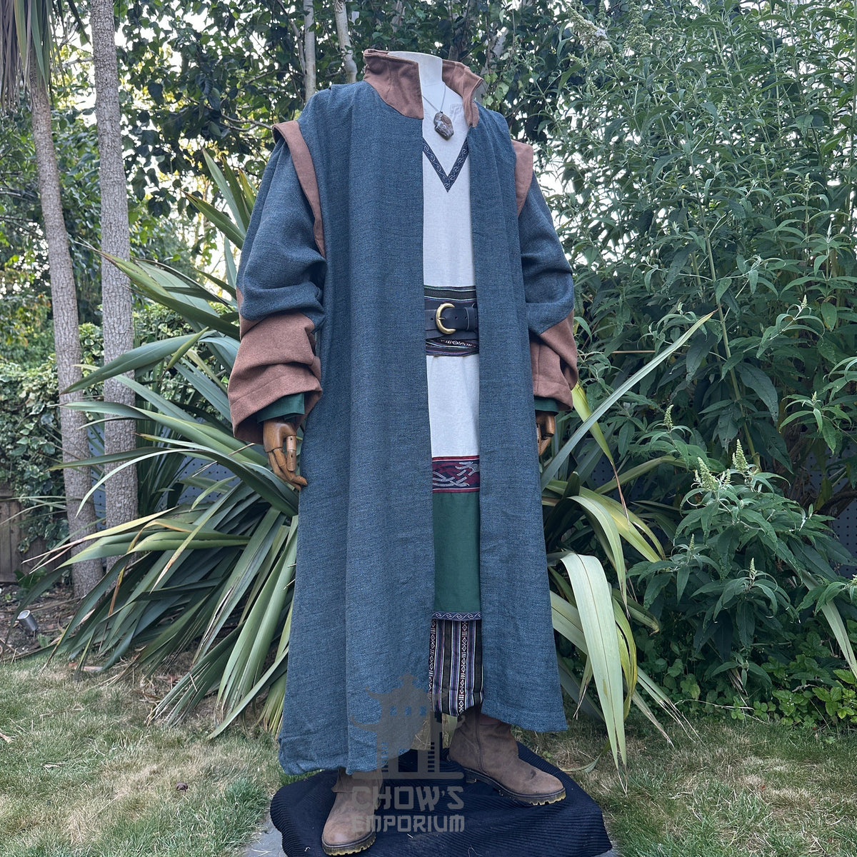 Medieval LARP costume side view featuring teal robe, tunic, pants, belt, sash and necklace.