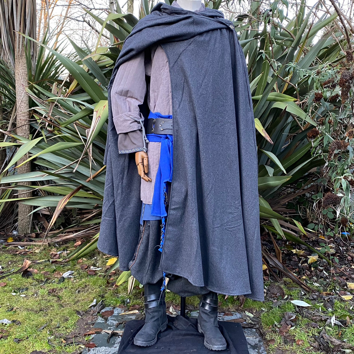 Dark grey cloak over grey gambeson, blue sash, and boots for LARP costume.
