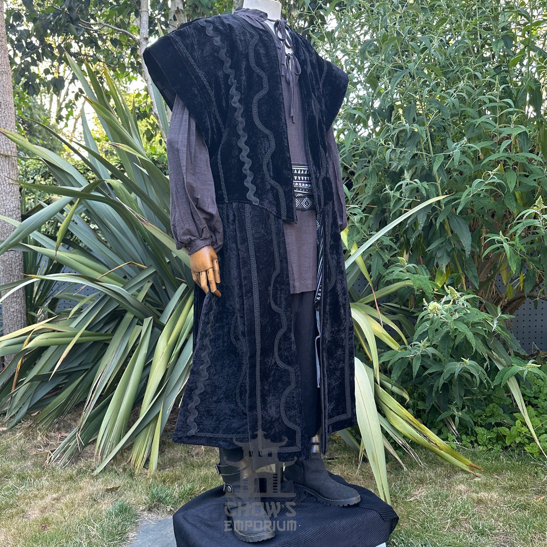 Medieval LARP costume side view featuring a black suede-effect waistcoat, grey shirt, and sash. For Renaissance Faire and historical roleplay events.