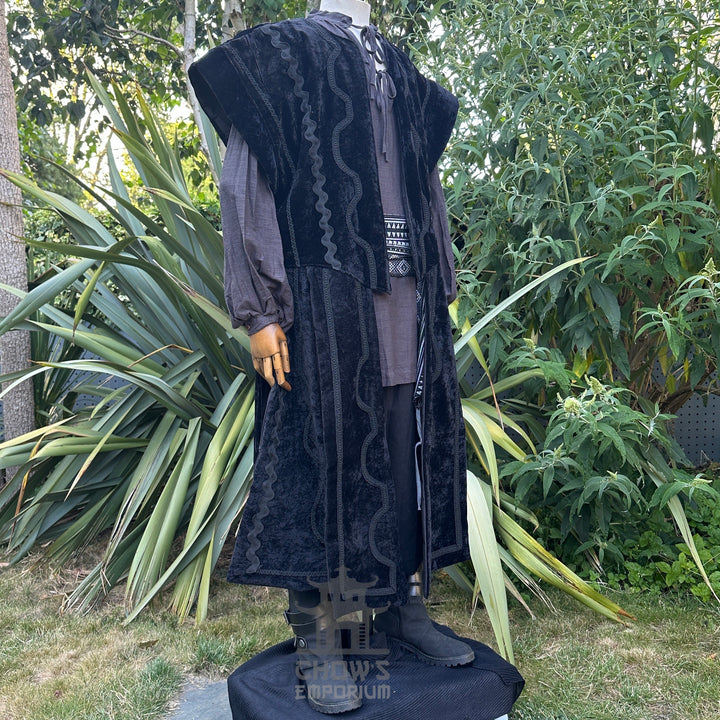 Medieval LARP costume side view featuring a black suede-effect waistcoat, grey shirt, and sash. For Renaissance Faire and historical roleplay events.