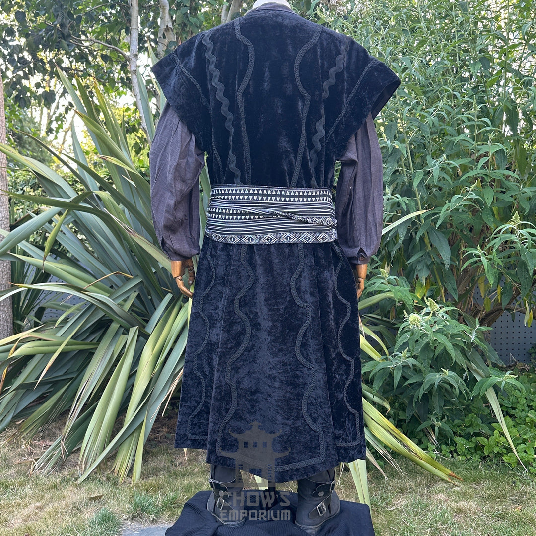 Medieval LARP costume back view featuring a black suede-effect waistcoat, grey shirt, and sash. For Renaissance Faire and historical roleplay events.