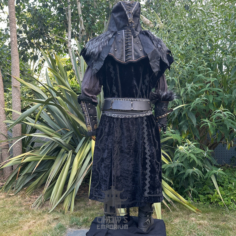 Medieval LARP costume back view featuring waistcoat, hood, vambraces, shirt, trousers, belt, and sash. For Renaissance Faire and historical roleplay events.