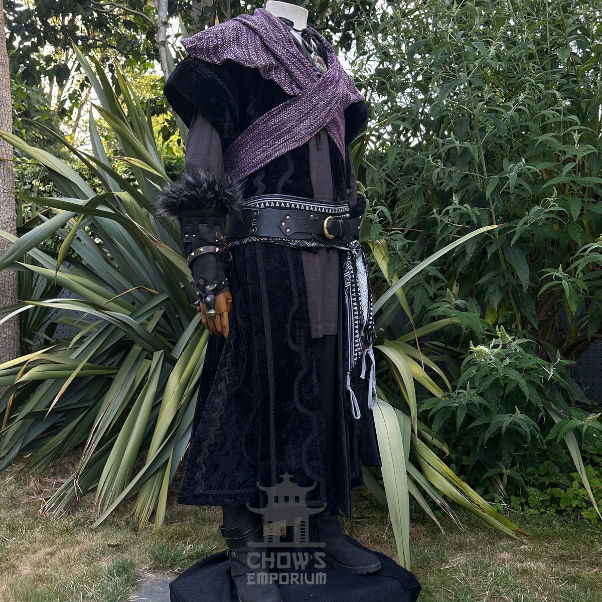 Medieval LARP outfit side view, featuring black suede-effect waistcoat, purple hood and sash.