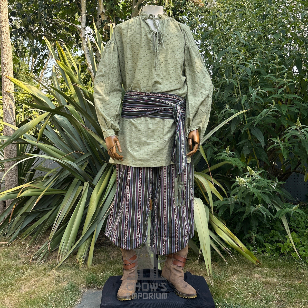 Green medieval LARP robe with striped pants and sashes.