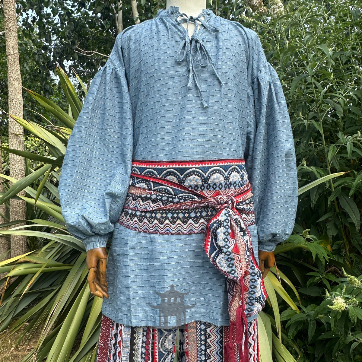 Blue medieval shirt with red nordic zigzag sash and matching patterned pants.