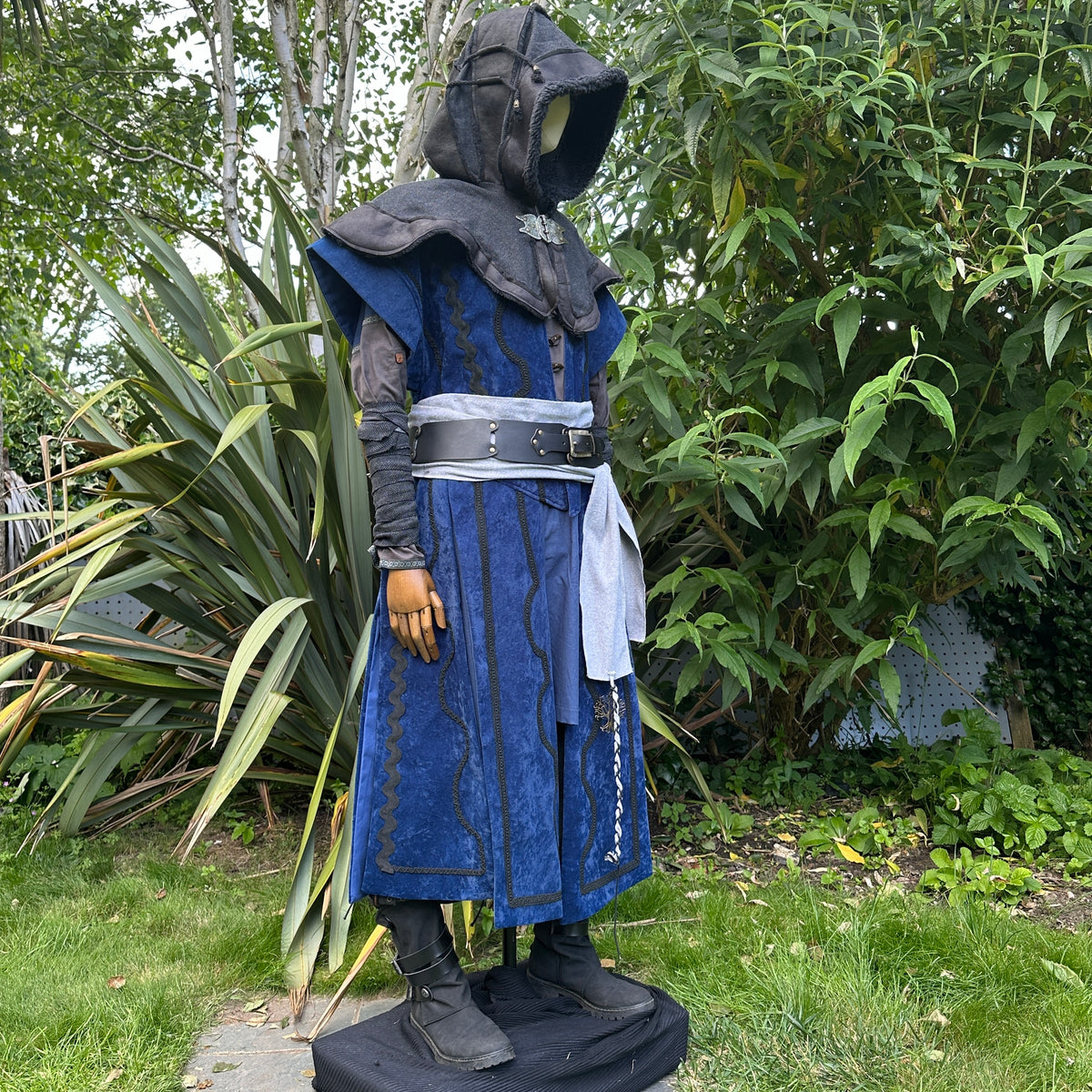 Medieval LARP costume side view, featuring a blue suede-effect panel waistcoat, black layered.