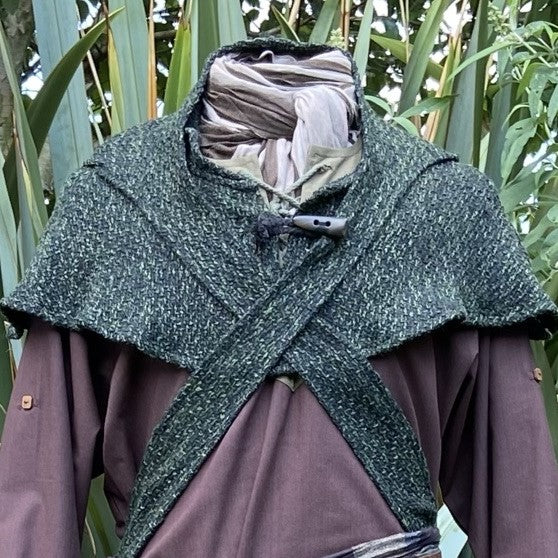 Green tweed hooded cloak over brown tunic, natural backdrop, LARP style.