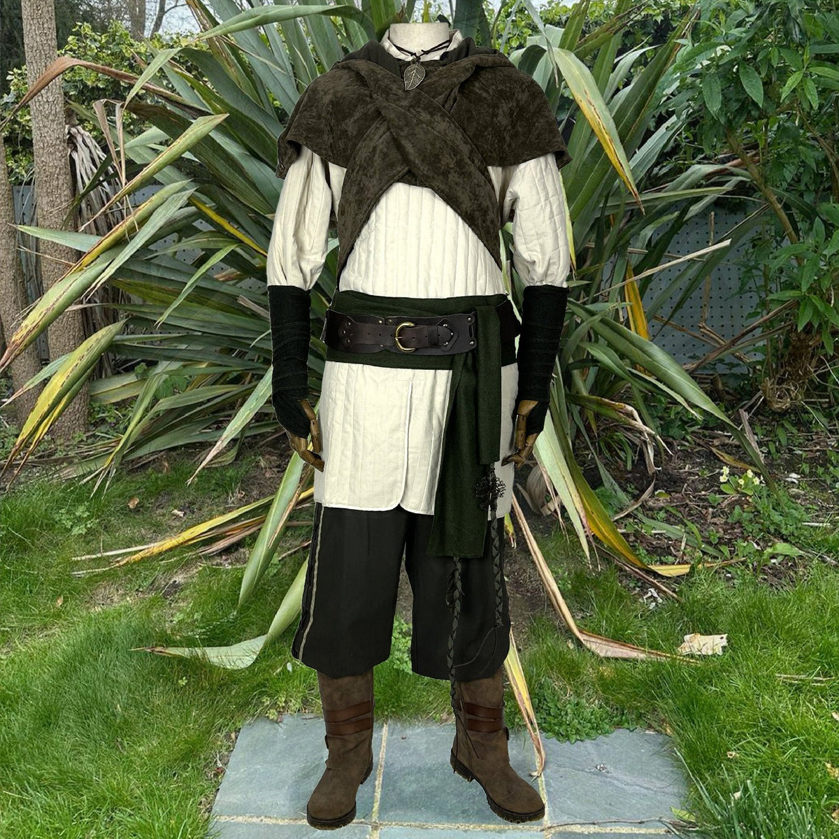 6 piece outfit with white padded gambeson, and green trousers, hood, armwraps and sash.