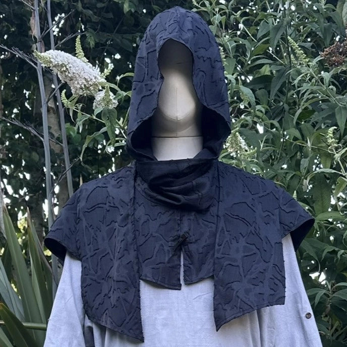 Black medieval scarf hood worn up over the head, face in shadow