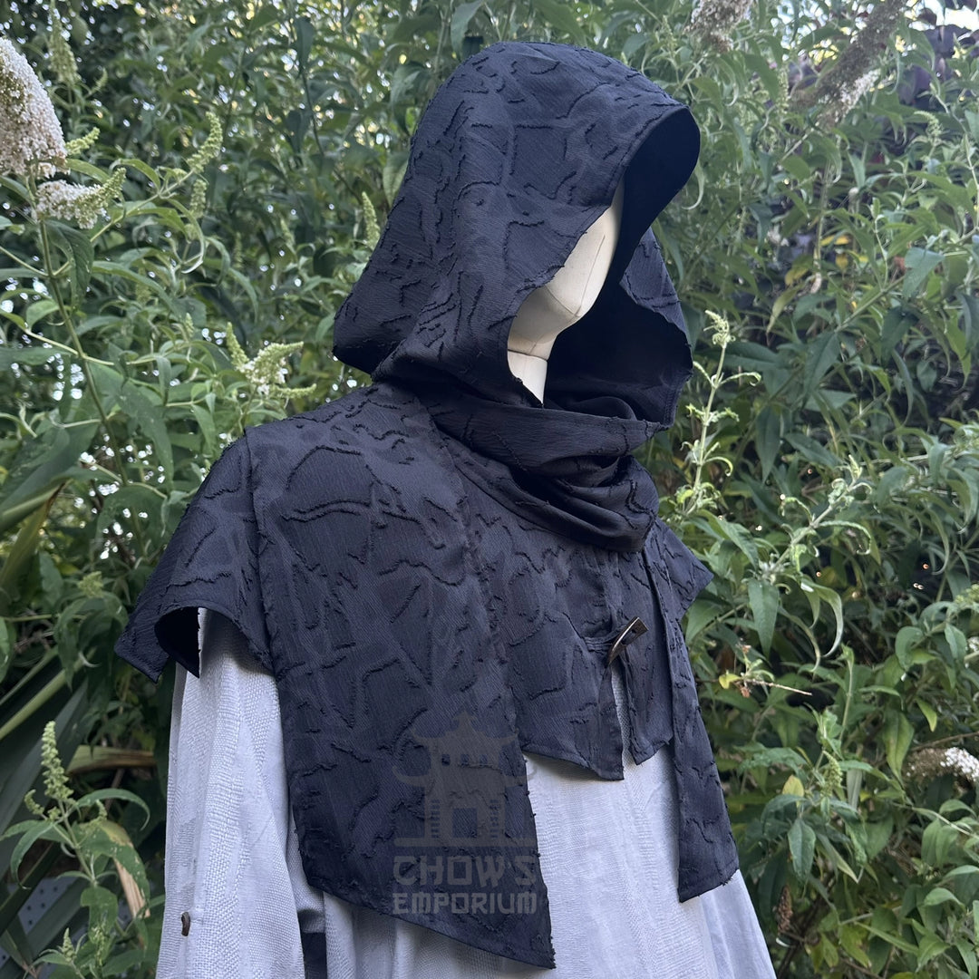 Black scarf hood worn as a cowl round the shoulders over a shirt