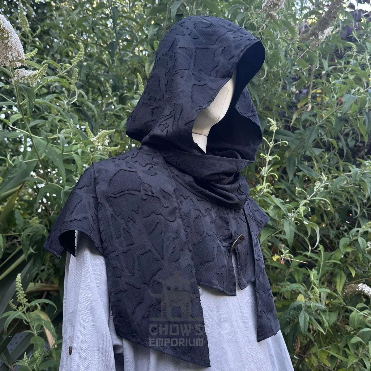 Black scarf hood worn as a cowl round the shoulders over a shirt