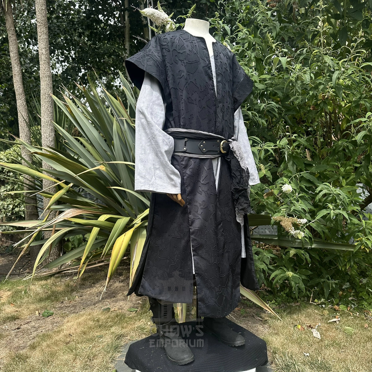 Black panelled waistcoat and hood set, hood down with a leather belt, three-quarter view. Belt sold separately.