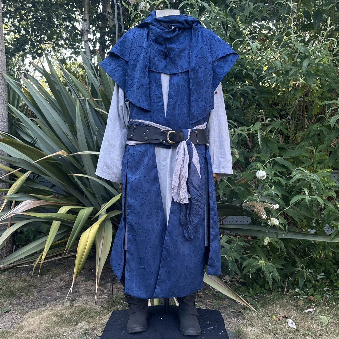 Close front view of the blue panelled waistcoat with the hood collar stood at the neck and a belt at the waist. Shirt and belt sold separately.