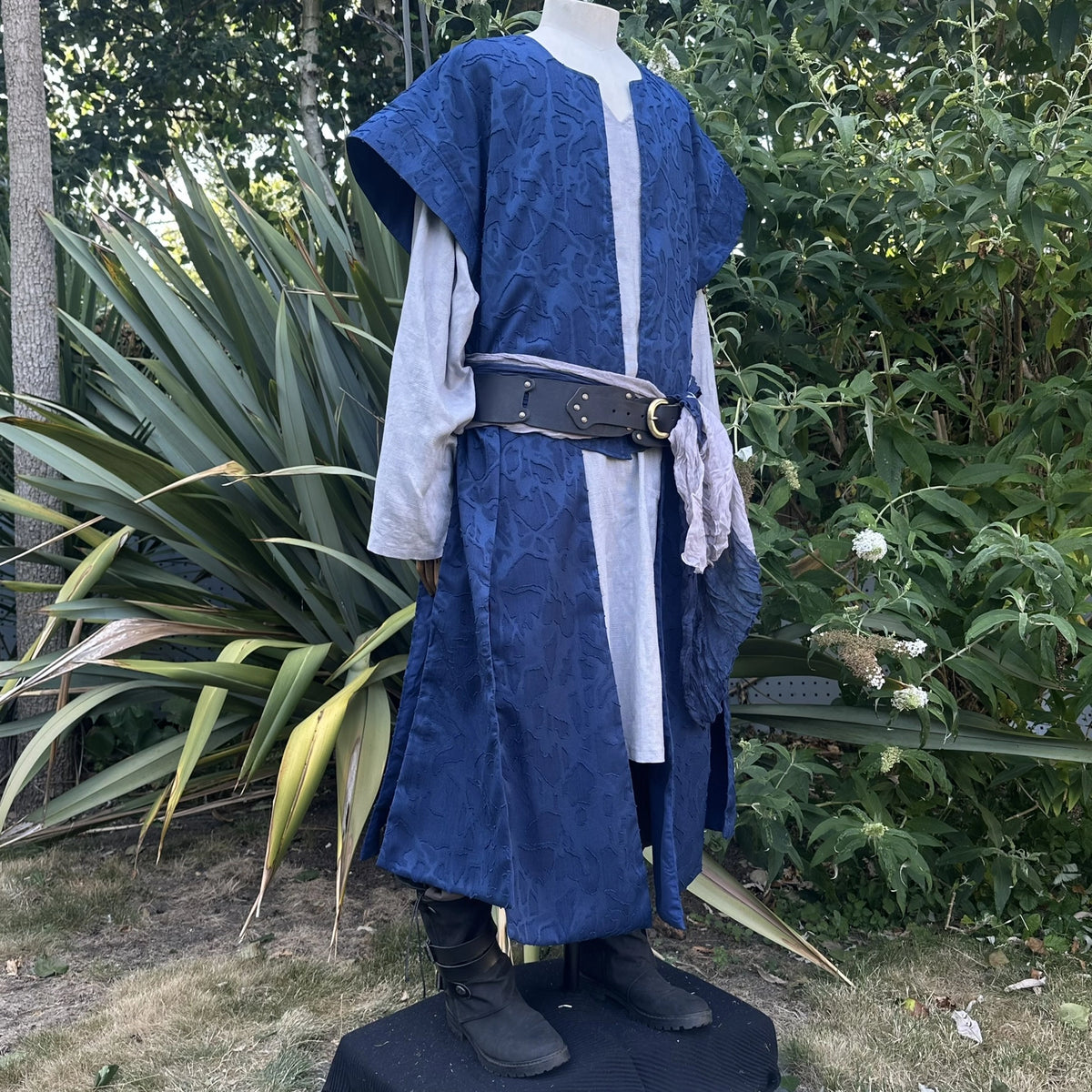 Blue panelled waistcoat and hood set, hood down, three-quarter view. Belt sold separately.