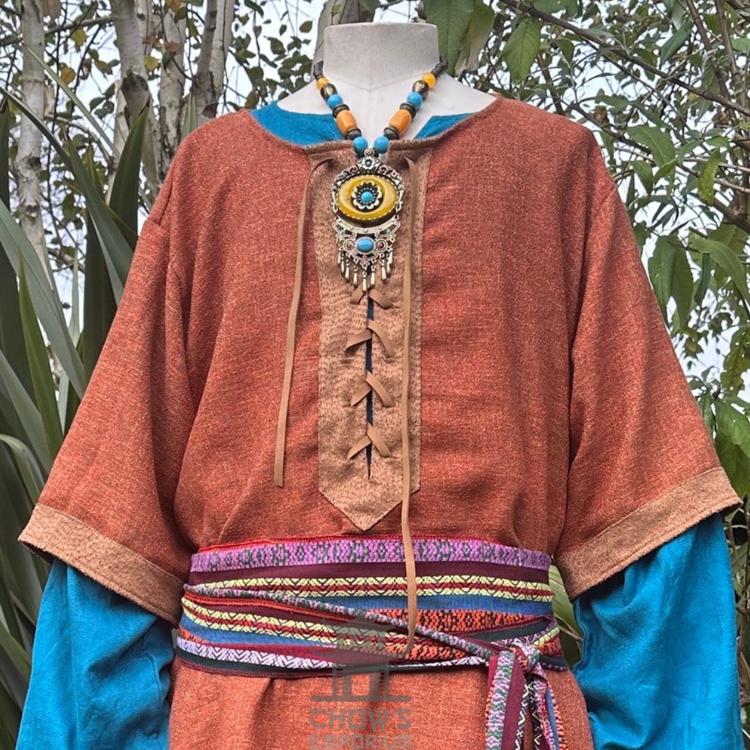 Rustic medieval tunic close-up with blue sleeves and beaded necklace for LARP.