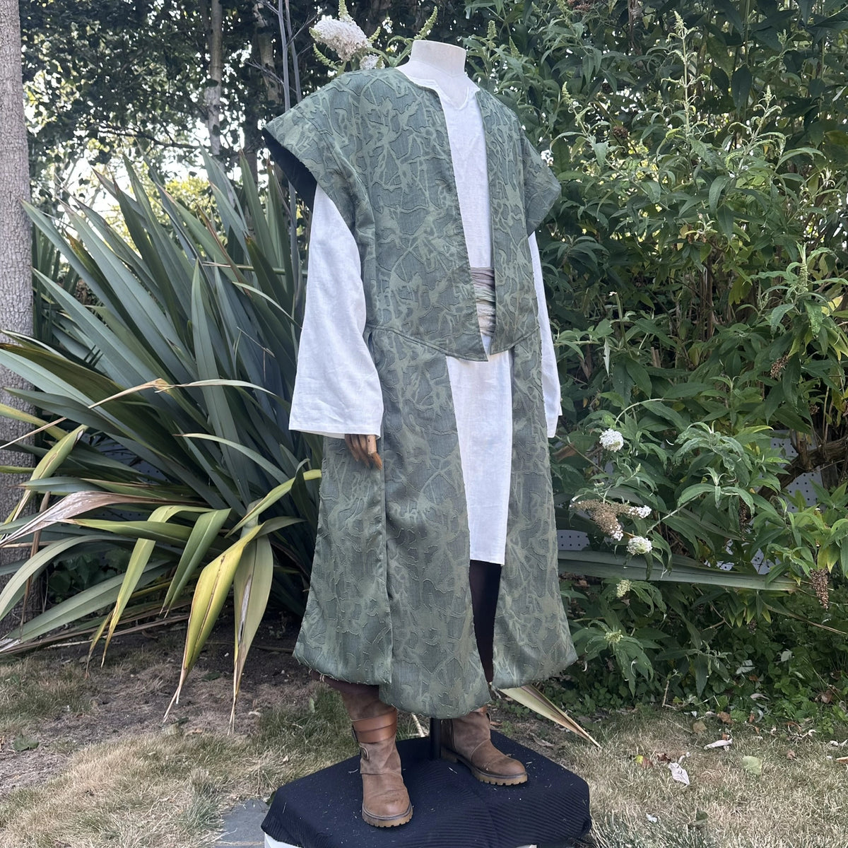 Green panelled waistcoat and hood set worn open with the hood down, back view showing the full-length panels over the shirt. Shirt sold separately.