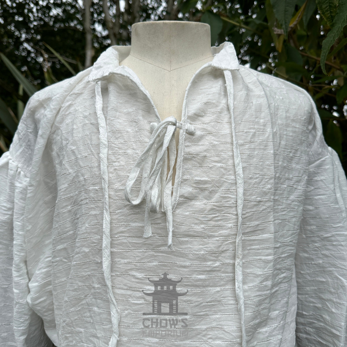 Close view of the lace-up neckline on the white medieval shirt