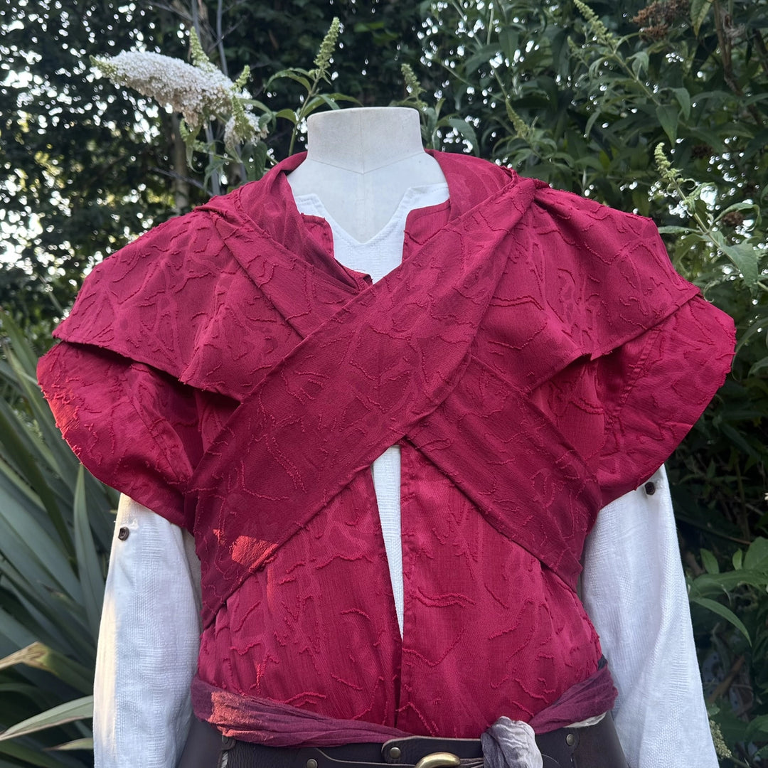 Close detail of the distressed red panelling across the chest of the waistcoat and hood set.