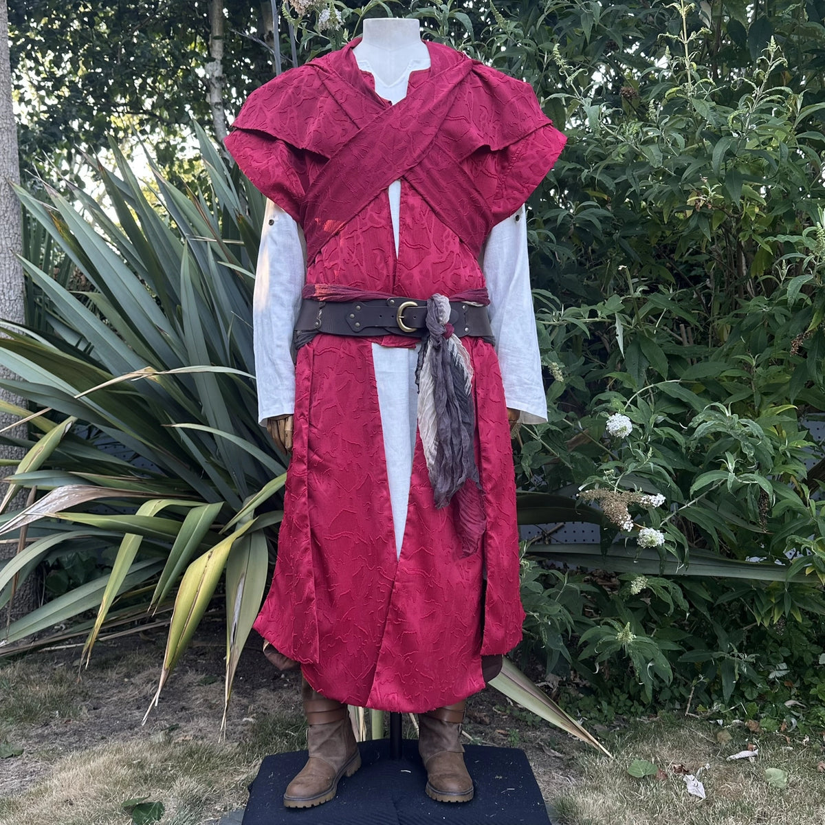 Red waistcoat and hood set with the hood crossed over the shoulders at the front. Shirt and belt sold separately.