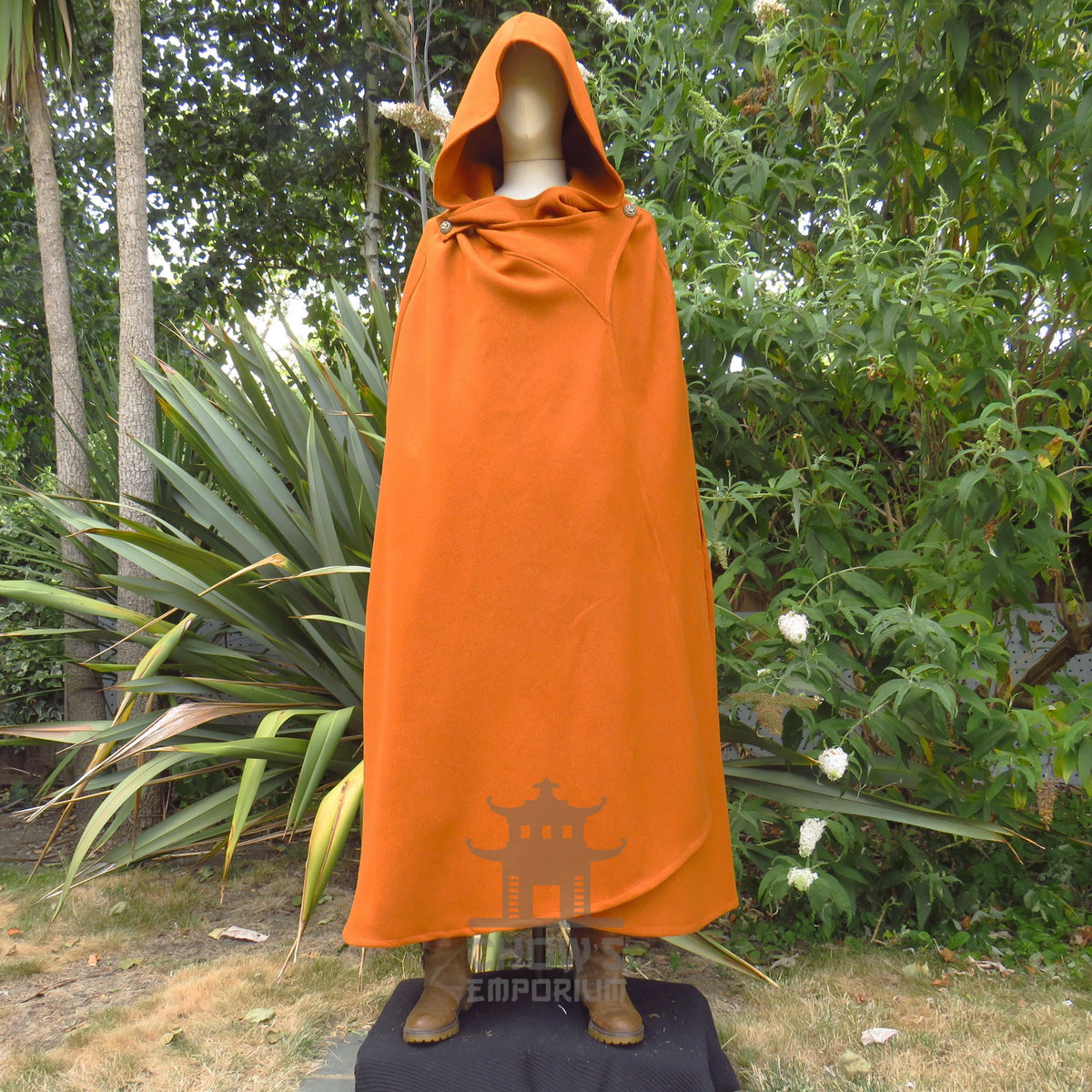 Rust wool hooded cloak worn closed with the deep hood pulled up, front view