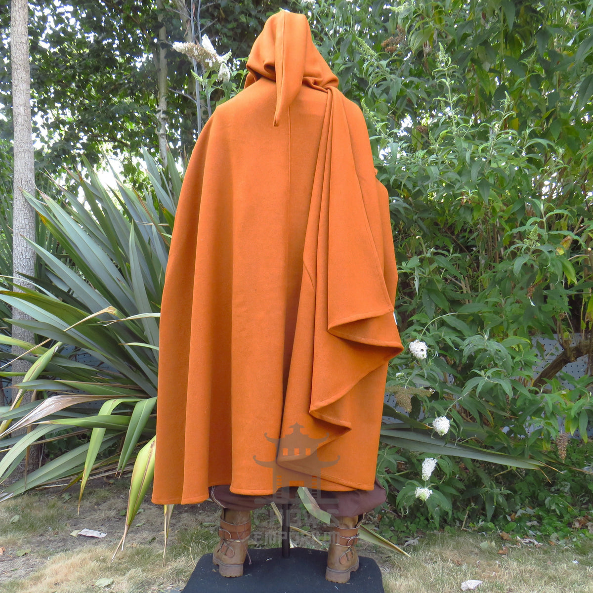 Rust medieval cloak from the back at full length, hood raised and the wool falling wide across the shoulders