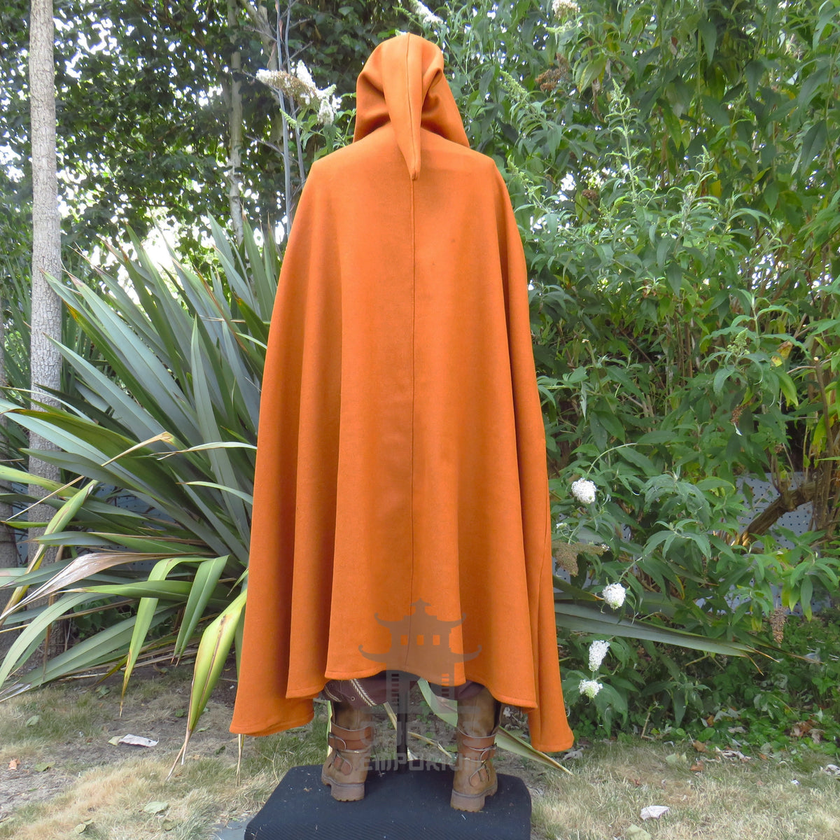 Rust wool cloak worn from behind with the deep hood pulled up, showing the shape of the hood on the shoulders