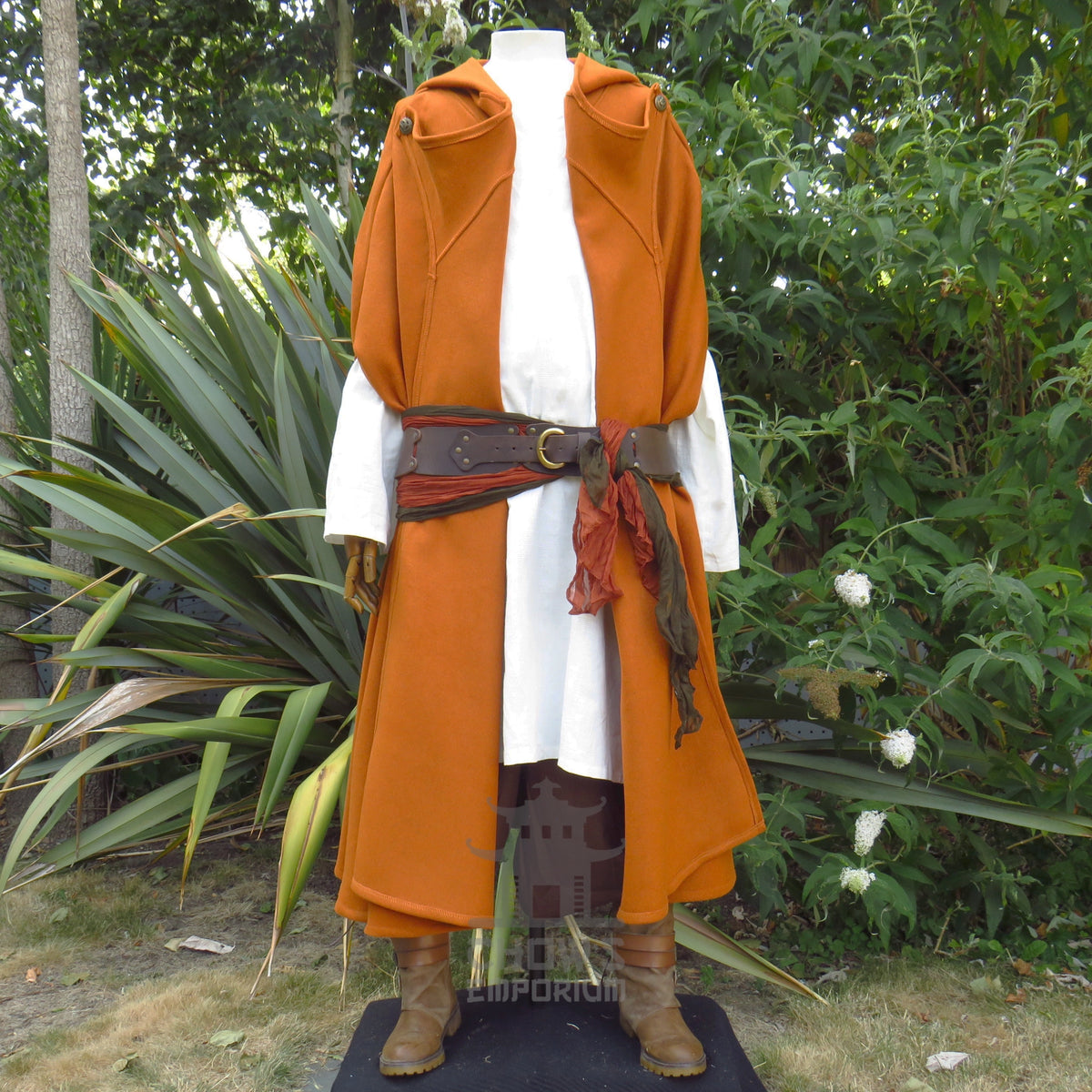 Rust wool cloak rebuttoned at the shoulders to sit as a robe, belted at the waist over a white tunic, belt and tunic sold separately