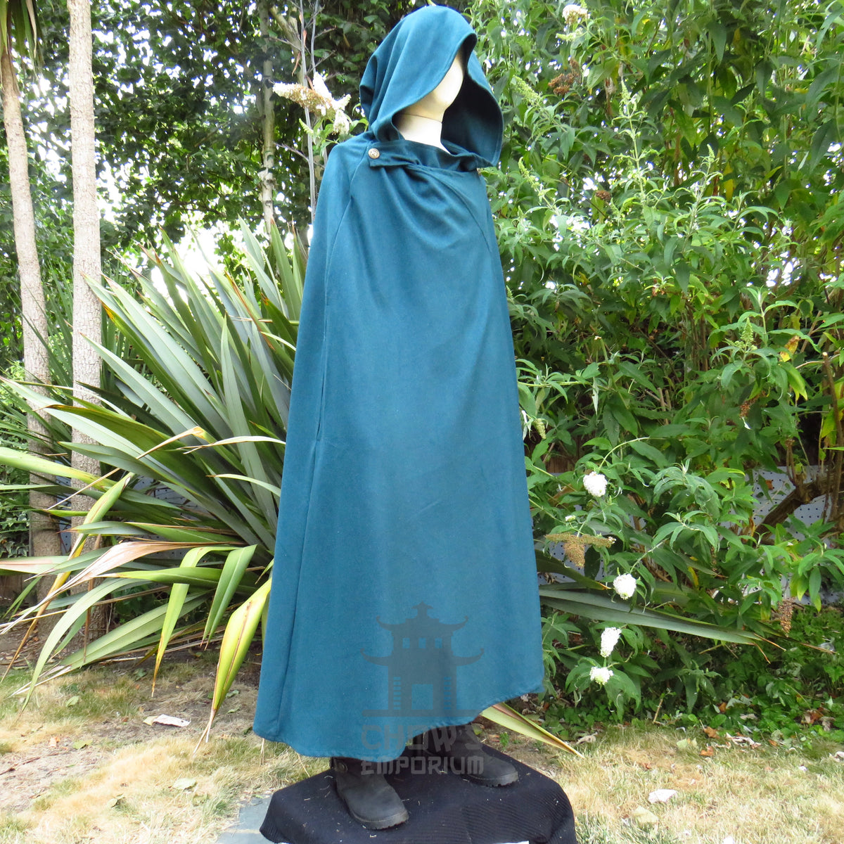 Teal wool hooded cloak worn closed with the deep hood pulled up, front view