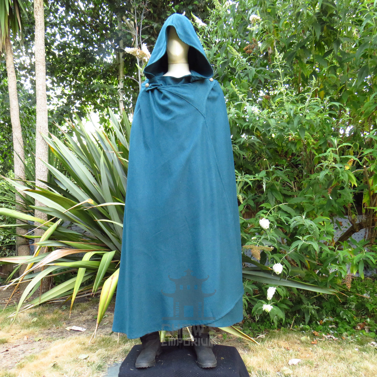 Teal wool cloak with the hood up and the neck left open at the throat