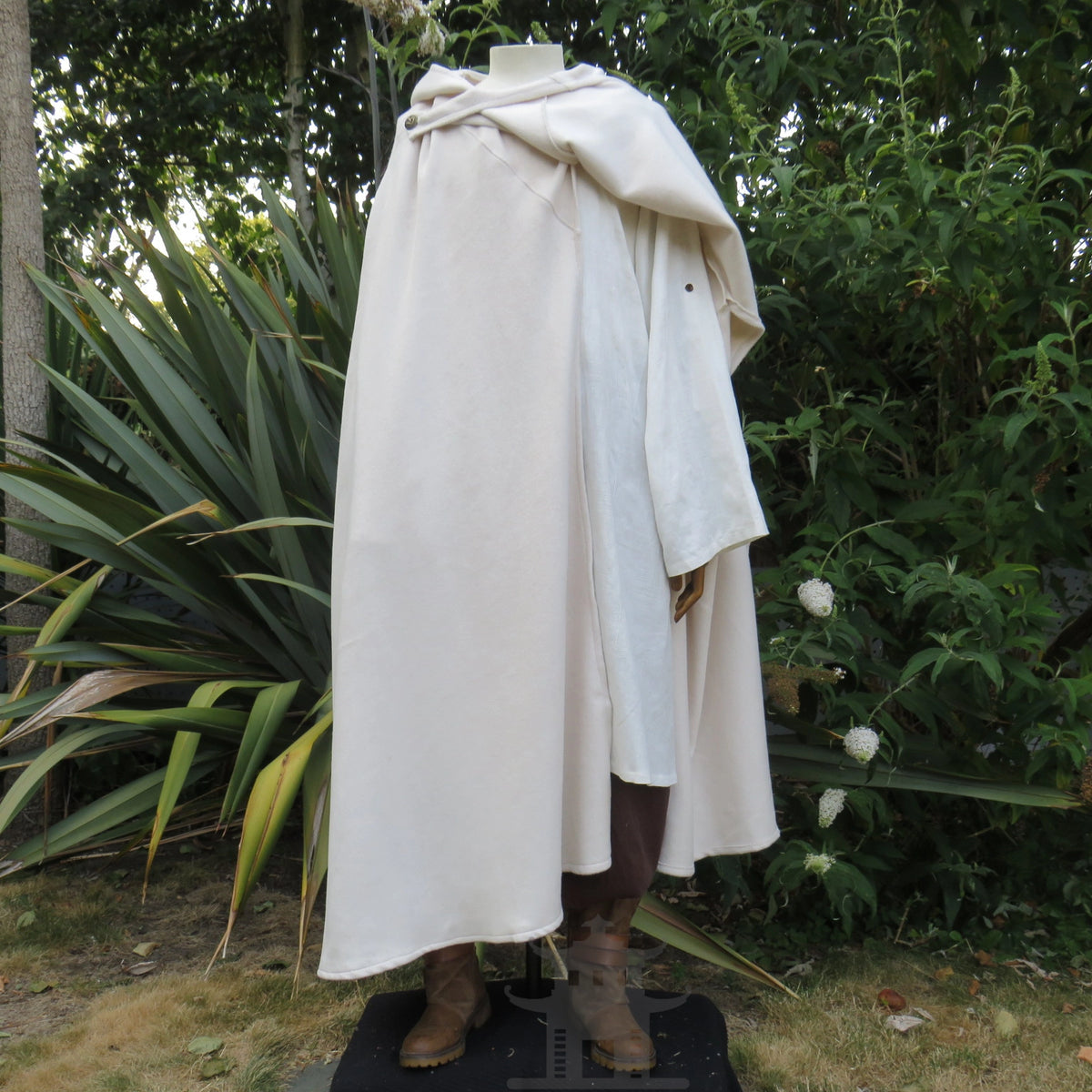 White wool cloak with one panel folded back over the shoulder for weapon access