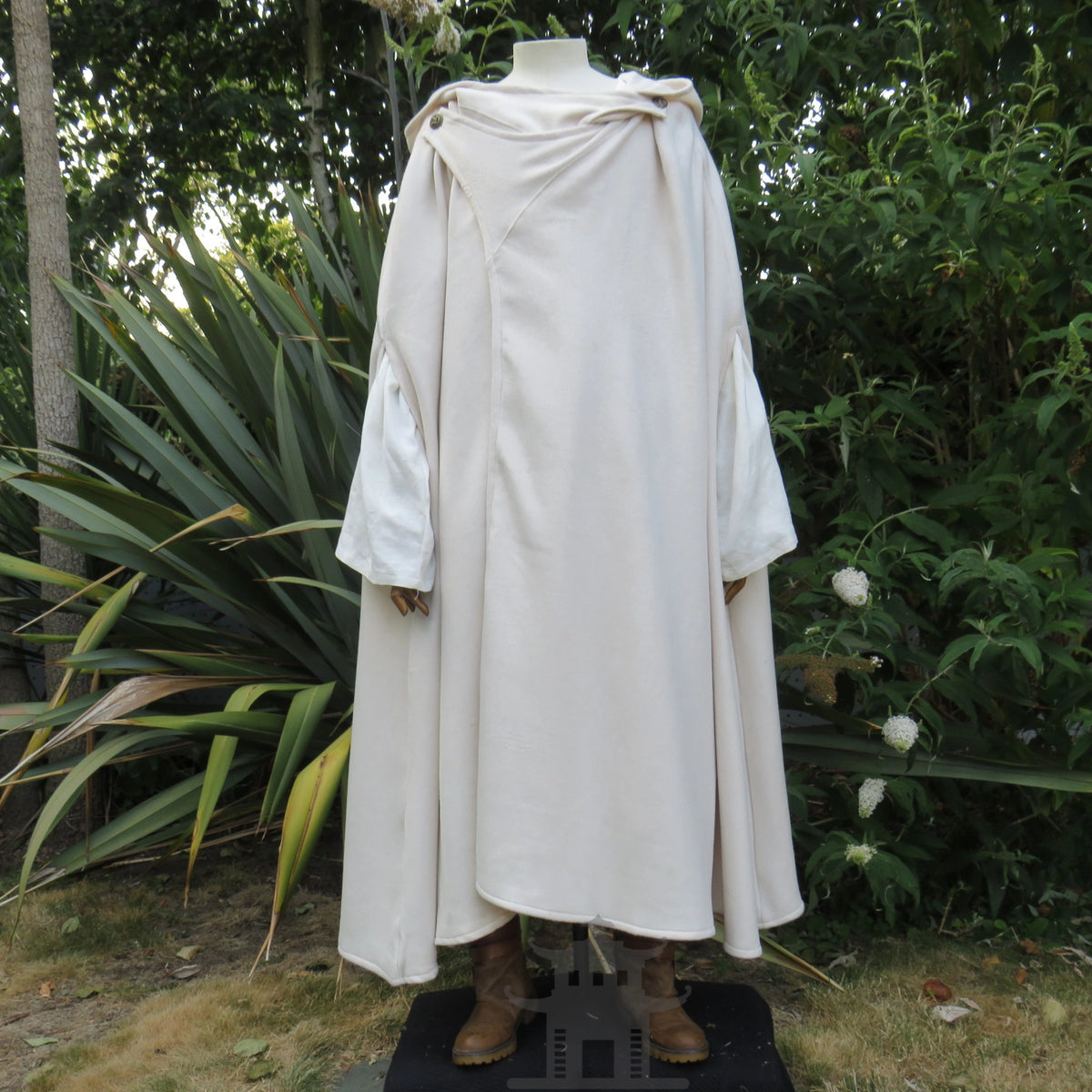 White cloak worn open over a pale tunic, sleeves showing at the sides