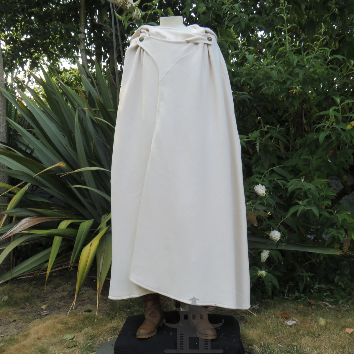 White hooded cloak with the hood folded back on the shoulders