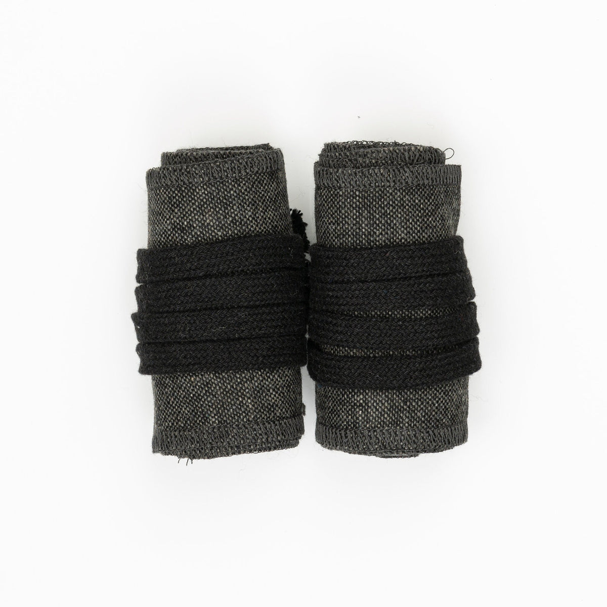 Light grey LARP wool arm wraps with black binding, top view.