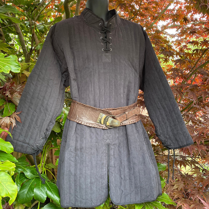 This Thin LARP Gambeson comes in Black Cotton. This Padded Tunic can sit on top of the rest of your kit. This Lightweight Gambeson is water resistant and keeps you warm. This Viking Tunic is perfect for your LARP Costume and LARP Character, Cosplay Events, and Ren Faires.