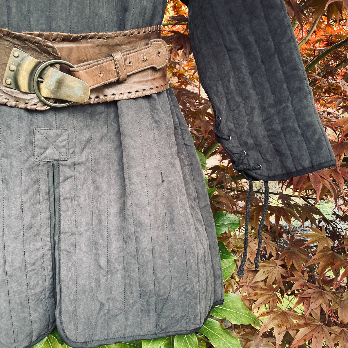 LARP gambeson close-up with brown belt and stitched sleeves.