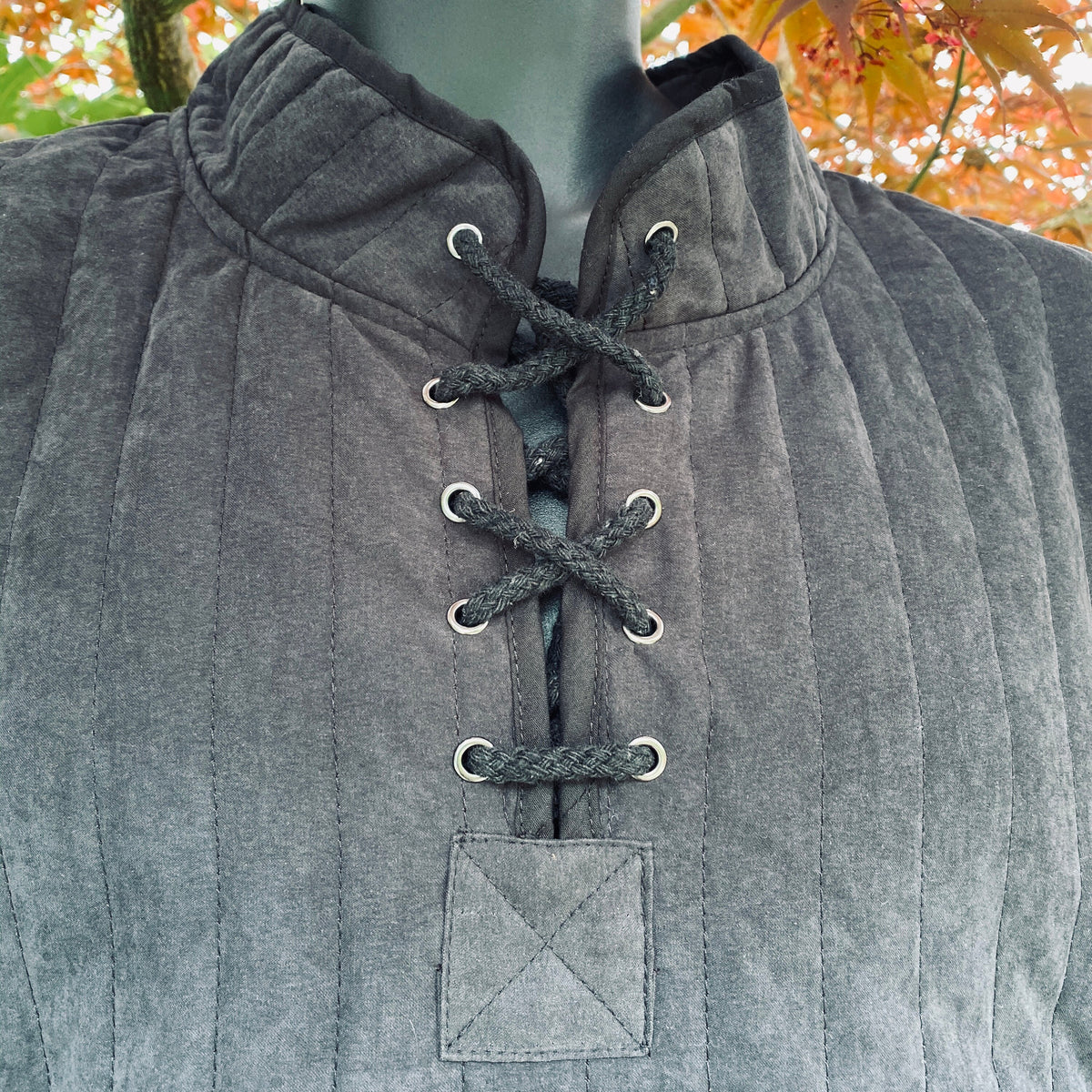 Close-up of black cotton gambeson with crisscross lacing for LARP or medieval.