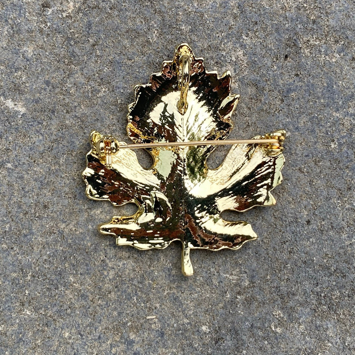 Gold leaf brooch back view on stone, medieval LARP accessory pin closure.