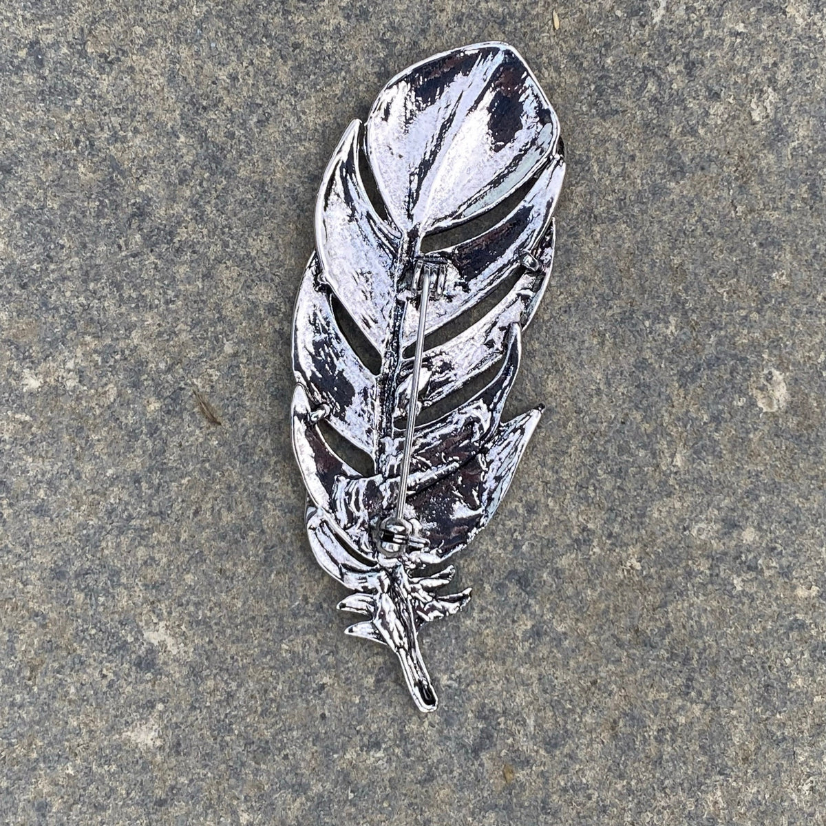 Silver feather brooch pin with house sigil, detailed texture, medieval LARP style.