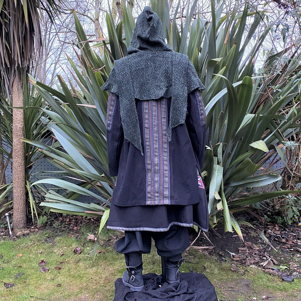 Medieval LARP costume back view, featuring a black and grey wool jacket with ornate panels, a two-tone linen tunic, and a sash. For Renaissance Faire and historical roleplay events.