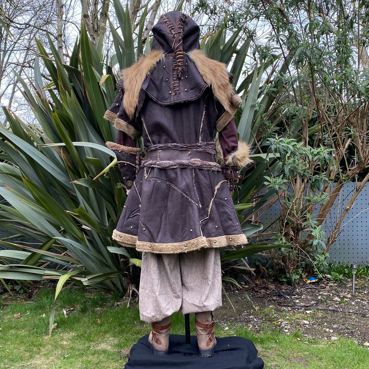 Back view of medieval LARP outfit; fur-trimmed hood and layered textures.