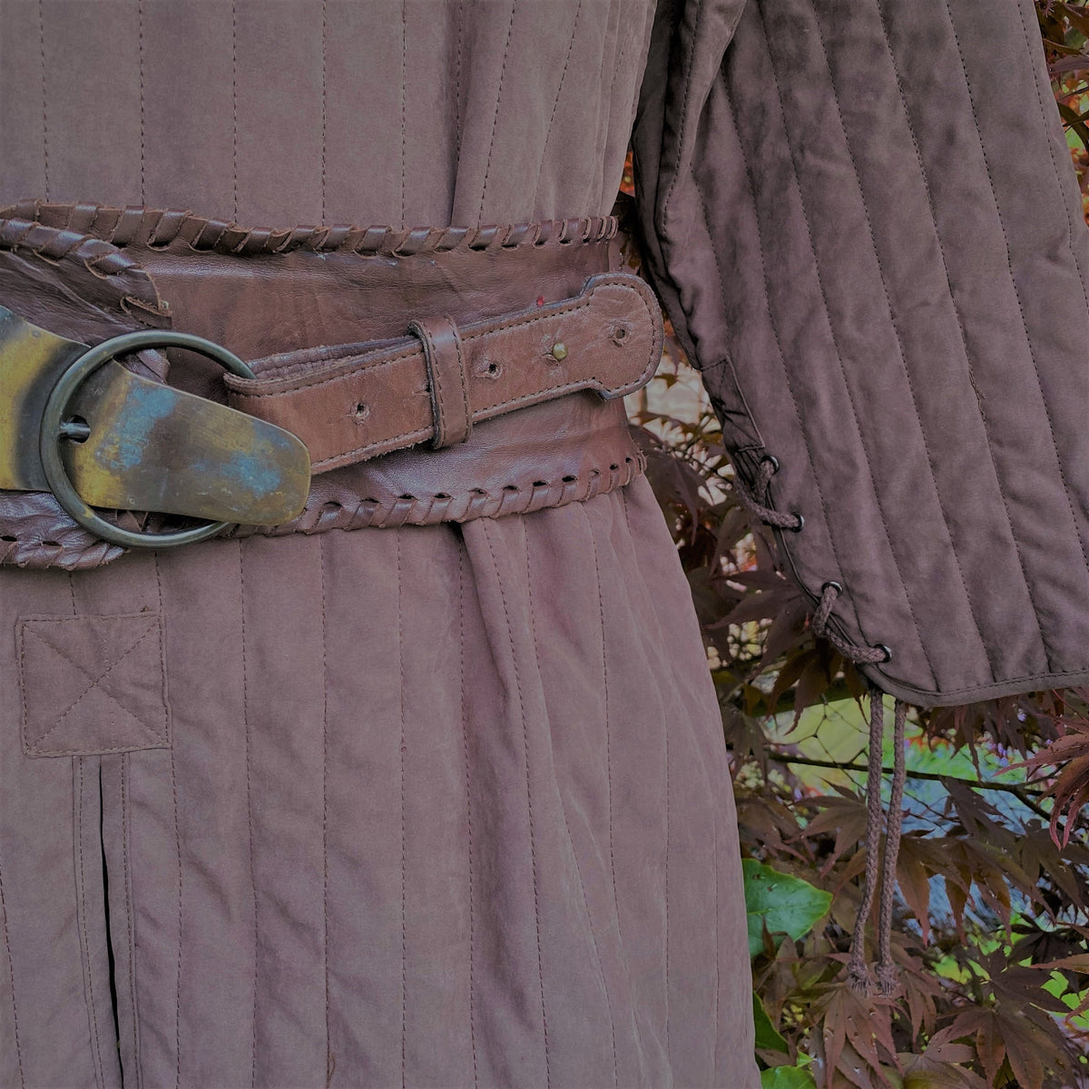 close up quilted stitching detail on brown gambeson.