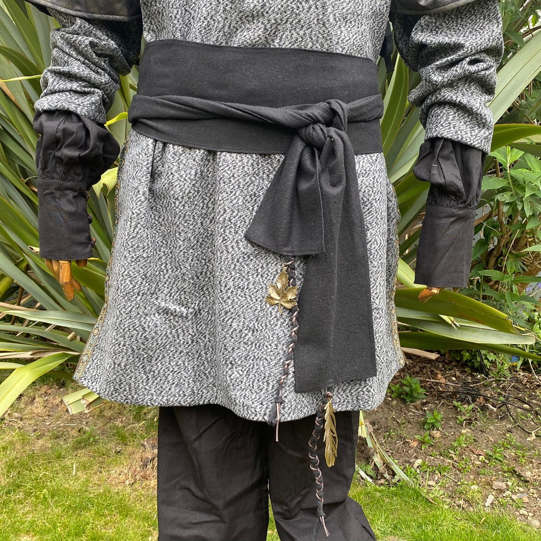 A Black Wool LARP Sash. The Viking Sash is a Woollen sash that works well by itself, or underneath a LARP Belt. The LARP Sash is 300cm long, and can comfortably wrap around you. The Medieval Sash has a decorated metal accessories that adds to your LARP Character, Cosplay, or Ren Faire event.