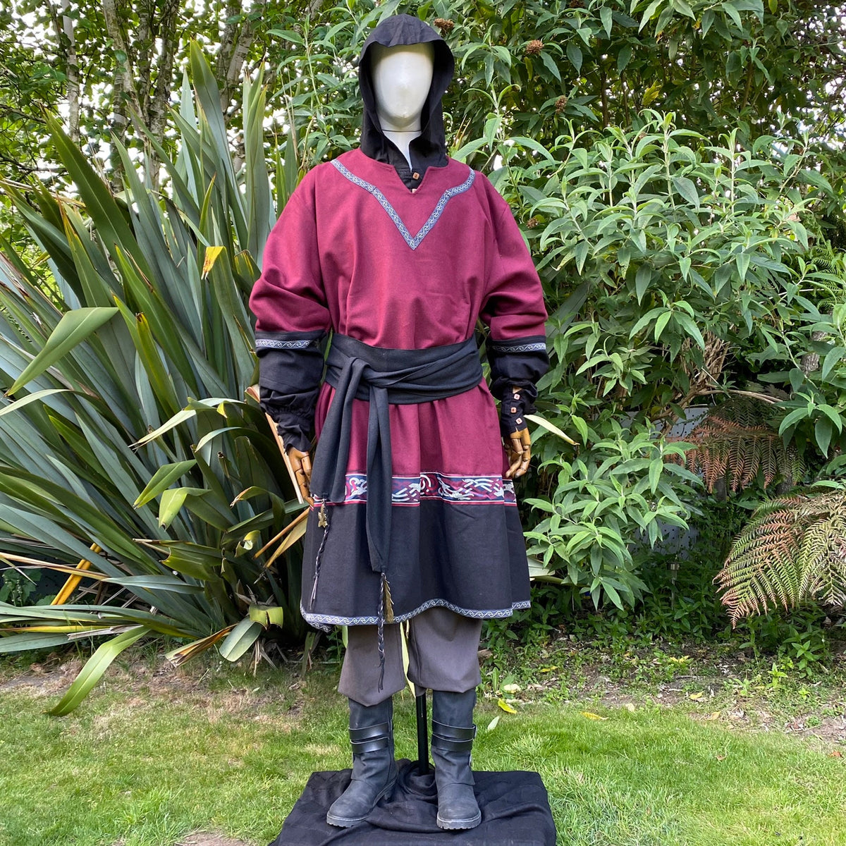 Medieval LARP attire with black hooded tunic and detailed sash.